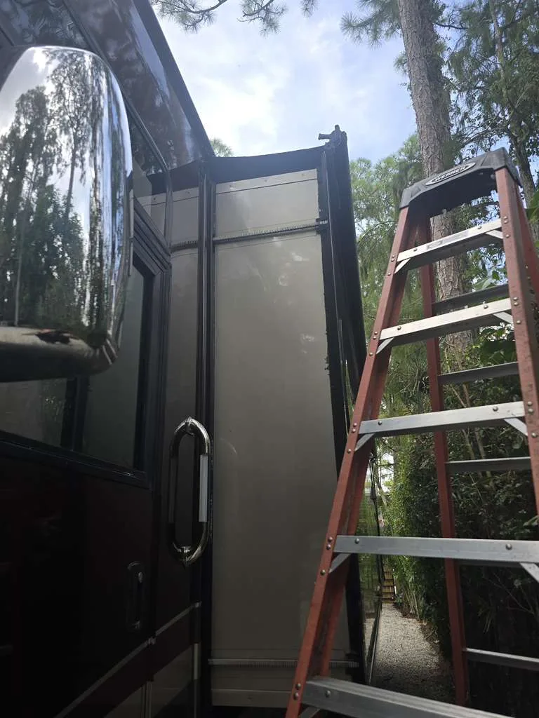 Tidepool RV technician working on a stuck slide-out at a Florida campsite